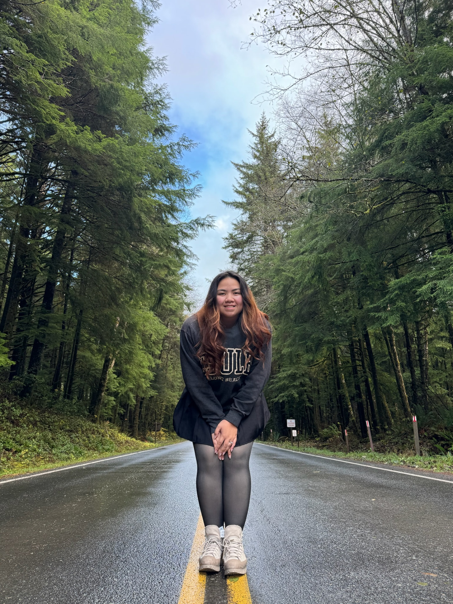 Sam standing on a road through a green forest